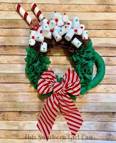 a christmas wreath with marshmallows, candy canes and bows on it