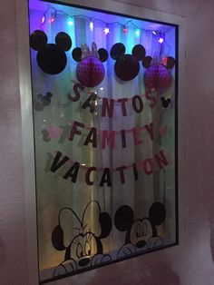 a window decorated with mickey mouse and minnie mouse heads for a family vacation at disney world