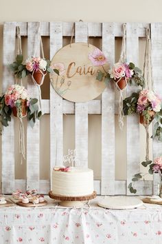 a cake sitting on top of a wooden table next to flowers and greenery in front of a sign that says caja