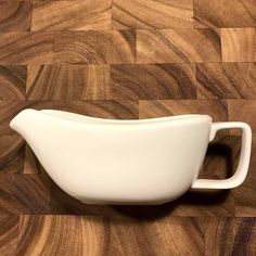 a white vase sitting on top of a wooden floor