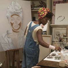 a woman is painting in an art studio