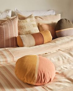 a bed topped with lots of pillows on top of it