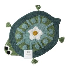 a green rug with a flower on it