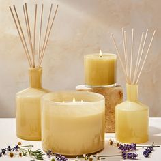 three candles, one with reeds and the other with lavender