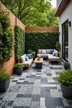 an outdoor living area with couches, tables and potted plants on the ground