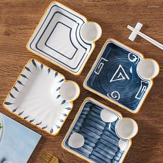 three blue and white trays with designs on them sitting on a wooden table top