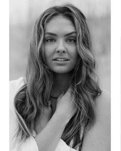 a black and white photo of a woman with her hands on her chest looking at the camera