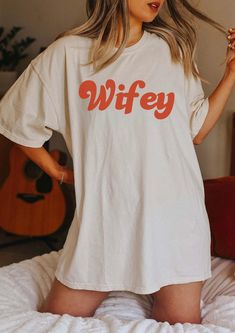 a woman standing on top of a bed wearing a t - shirt that says mrs cooper