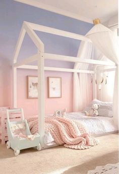 a white canopy bed sitting in a bedroom next to a pink chair and rug on the floor