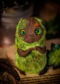 a green stuffed animal sitting on top of a table