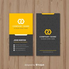 a black and yellow business card on wooden background