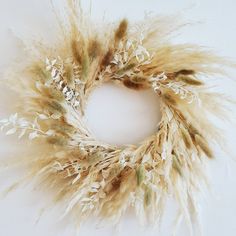 a wreath made out of dried grass on a white background