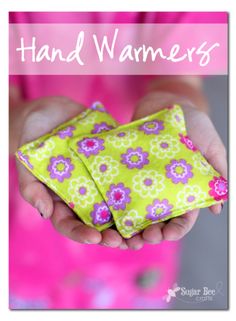 a person holding a small yellow flowered cloth in their hands with the words hand warmers on it