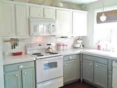 a kitchen with white appliances and gray cabinets