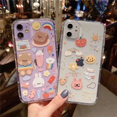 two phone cases with stickers on them in front of a store display case, one is purple and the other is blue