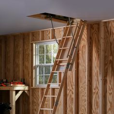 The W2508 wood attic ladder has duty rating of 250 pounds and comes fully assembled and ready to install. Full wrap-around door hinge minimized heat loss. The quality door is ready for staining or painting. the pull string eases the opening and closing. Hinges butt metal to metal to maintain ladder rigidity. Counter-balance mechanism eliminates sag and springiness. Werner Wood Folding Attic Ladder 7-ft to 8.75-ft (Rough Opening: 25-in x 54-in) with 250-lb Capacity in Brown | W2508 Wood Attic, Attic Access Ladder, Counter Balance, Attic Ladder, Old Ladder, Door Hinges, Hinges, Tiny House, Flooring