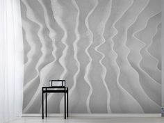 a chair sitting in front of a wall with wavy designs on it's sides