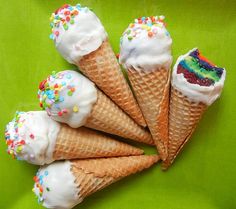 five ice cream cones with sprinkles on a green plate