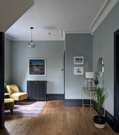 a living room with a radiator, chair and painting on the wall in it