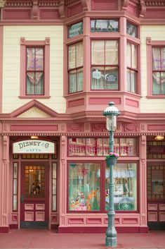 a pink and yellow building with many windows on the front, and a street light in front