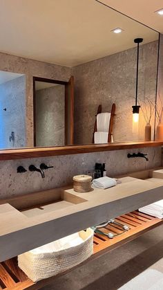 a bathroom with two sinks, mirrors and towels on the counter top in front of it