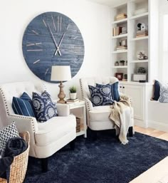 a living room filled with furniture and a large blue clock on the wall above it