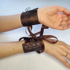 two hands with wristbands tied together holding onto each other