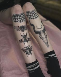 two legs with tattoos on them that have animals, bees and deer skulls on them