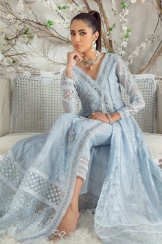 On a canvas of refreshing sky-blue hue, this silk net effortless, flowing angrakha kalidar is adorned with delicate shimmering swarovski crystals, pearls, sequins, mirror & silk thread work in dreamy pastel hues. Glamorously composed sleeves, hand-crafted glistening tassels, embroidered border & scalloped laces complete its look. This stunning floor-length kalidar is off set with a ruffle detailed draped dupatta and lace detailed stylish pant adding distinct elegant flair to entire look. Shirt F Blue Silk Shirt, Wedding Doves, Pakistani Boutique, Sky Blue Dress, Pakistani Designer Clothes, Organza Sleeves, Stylish Pants, Organza Dupatta, Net Dupatta