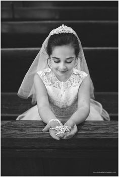 a woman in a wedding dress sitting on the steps with her hands together and looking down