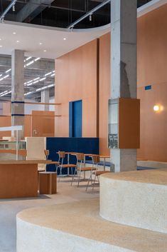 an empty room with several tables and chairs in the center, some are made out of plywood