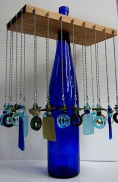 a blue glass bottle with lots of keys hanging from it's side and some chains attached to the bottom