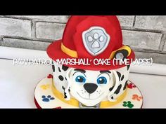 a cake that is decorated to look like a fireman's hat with paw prints on it