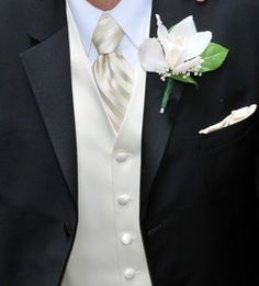 a man in a tuxedo with a boutonniere and flower on his lapel