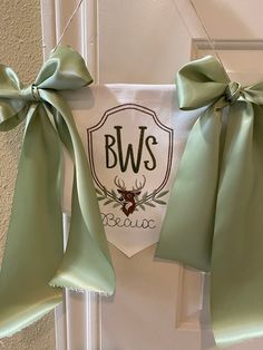 two bows hang on the front door of a house with bow ties hanging from it's side