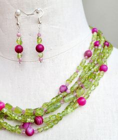 Strung with an assortment of polished and faceted lime green peridot stones, pink tourmaline stones, and round pink agate stone on six wires, this necklace is finished with decorative bead caps and a lobster clasp.  Necklace measures 20 inches long. Matching beaded earrings are hung on 925 silver ear wires. Pink Double Strand Gemstone Beads Jewelry, Green Multi-strand Jewelry With Colorful Beads, Multi-strand Green Jewelry For Gift, Green Multi-strand Jewelry Gift, Green Multi-strand Jewelry For Gift, Elegant Lime Green Beaded Jewelry, Green Multi-strand Beaded Necklace With Natural Stones, Colorful Beaded Lime Green Jewelry Gift, Lime Green Jewelry With Colorful Beads As Gift