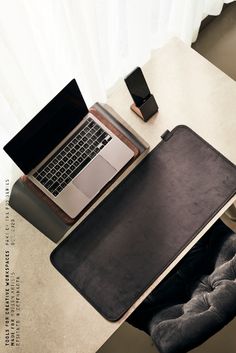 an open laptop computer sitting on top of a desk next to a phone and other items