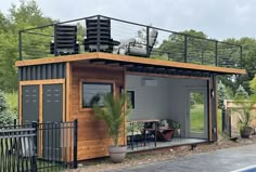 a house made out of shipping containers on the side of a road