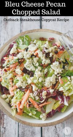 a salad with lettuce, carrots and feta cheese on top in a bowl