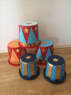 four circus themed cakes sitting on top of a wooden floor