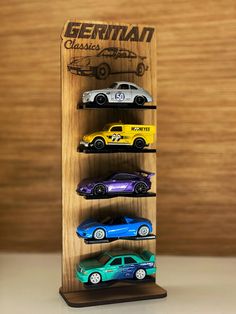 a wooden display case with six toy cars on it's sides and the words, german classic