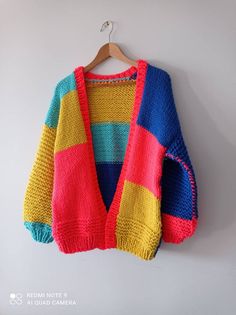 a multicolored sweater hanging on a hanger