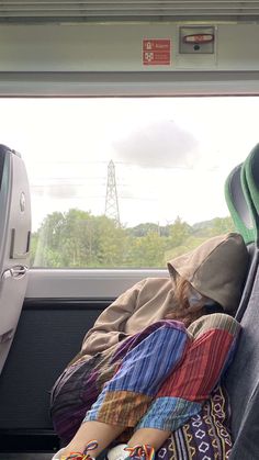 a person sleeping in the back seat of a car with their head on a pillow