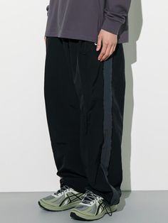 This is a comfortable and trendy pants that are made out of high quality nylon 100%  fabric. With design detail of wide silhouette, color blocked side panel, and minimal logo embroidery detail, it gives a trendy and modern look. - Deep tuck for wide silhouette- Adjsutable string on the hem- Elastic waistband with inner string Black Nylon Techwear Pants, Black Sporty Bottoms With Contrast Stitching, Black Nylon Wide Leg Parachute Pants, Black Wide Leg Nylon Parachute Pants, Black Nylon Streetwear Pants, Black Streetwear Pants With Contrast Color, Urban Black Nylon Bottoms, Black Pants With Contrast Color For Streetwear, Black Nylon Urban Bottoms