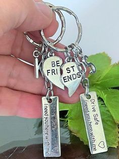 someone is holding two key chains that say, be friends and have hearts on them