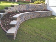 a stone retaining wall with steps leading up to it