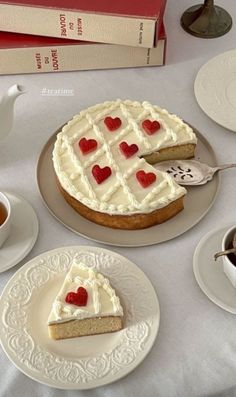 there is a cake with hearts on it and two cups of coffee next to it