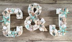 the letters are made out of seashells and starfish on top of wood