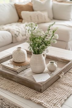 a tray with flowers on it sitting on a table in front of a white couch