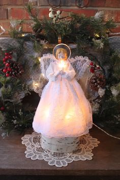 an angel figurine sitting on top of a table next to christmas wreaths